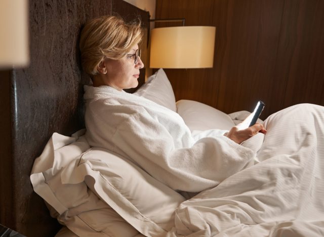 mature-woman-texting-in-bed-1702949972661521793291.jpg