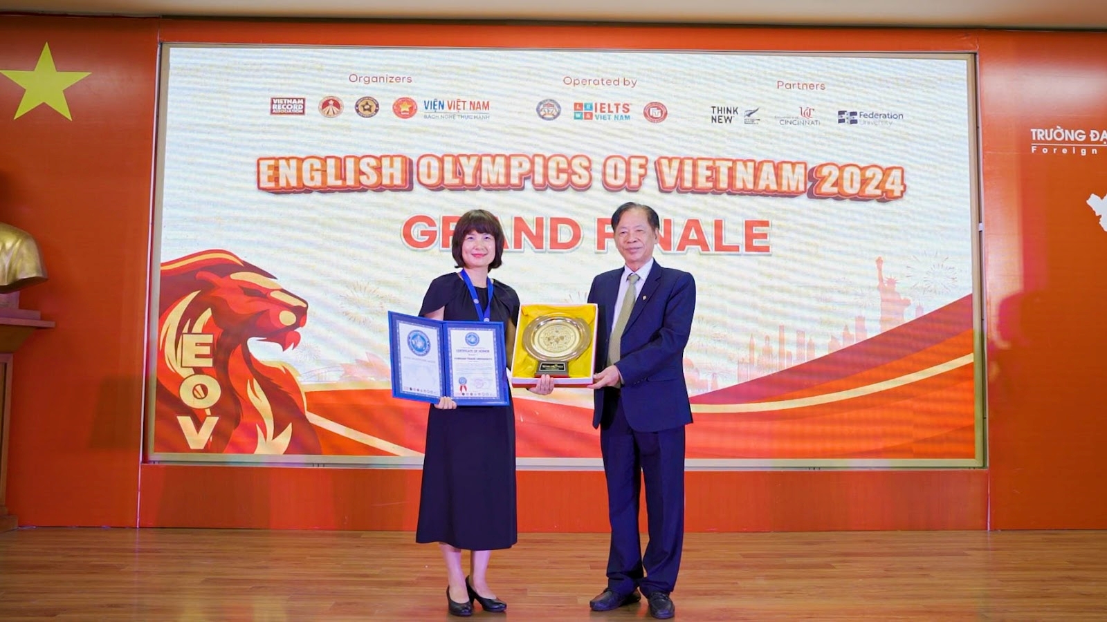 TS. Thang Văn Phúc - Nguyên Thứ trưởng Bộ Nội vụ, Chủ tịch Trung ương Hội Kỷ lục gia Việt Nam trao “Đĩa vàng Cống hiến” cho trường Đại học Ngoại thương - đơn vị đồng tổ chức, đăng cai Cuộc thi EOV 2024. PGS.TS. Phạm Thu Hương - Phó Hiệu trưởng Trường Đại học Ngoại thương, đại diện nhà trường nhận quà tri ân từ BTC Cuộc thi EOV